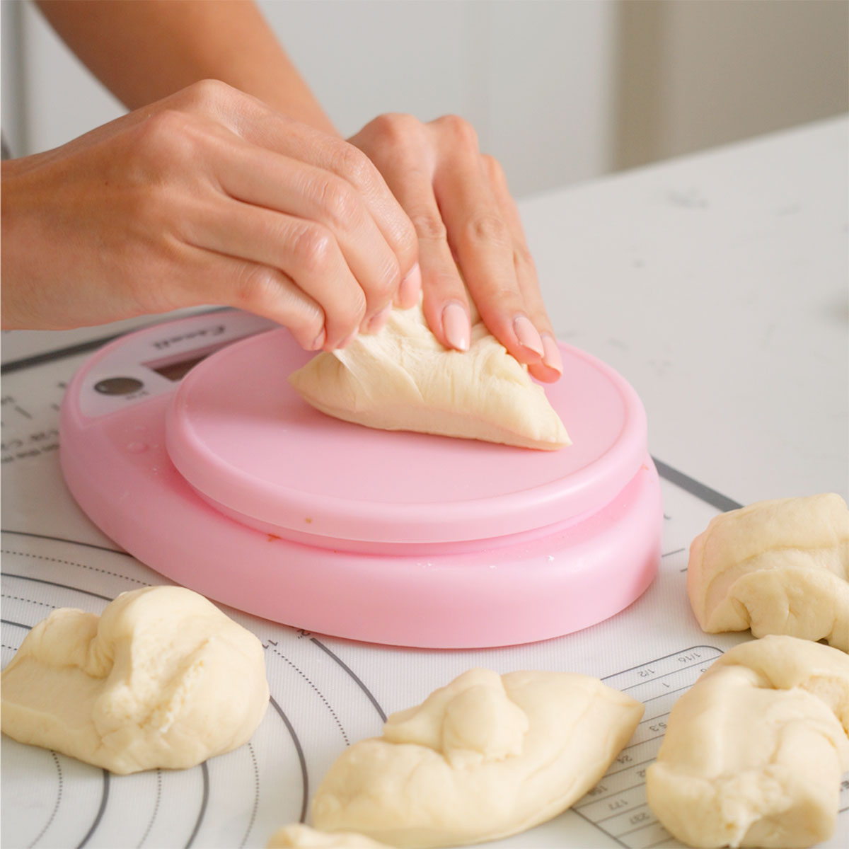 Measuring out the proofed dough into even balls.