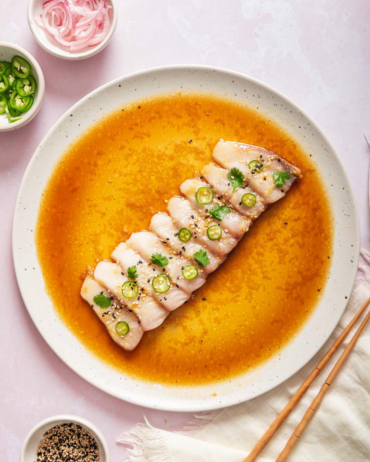 Looking down at a plate of hamachi crudo garnished.