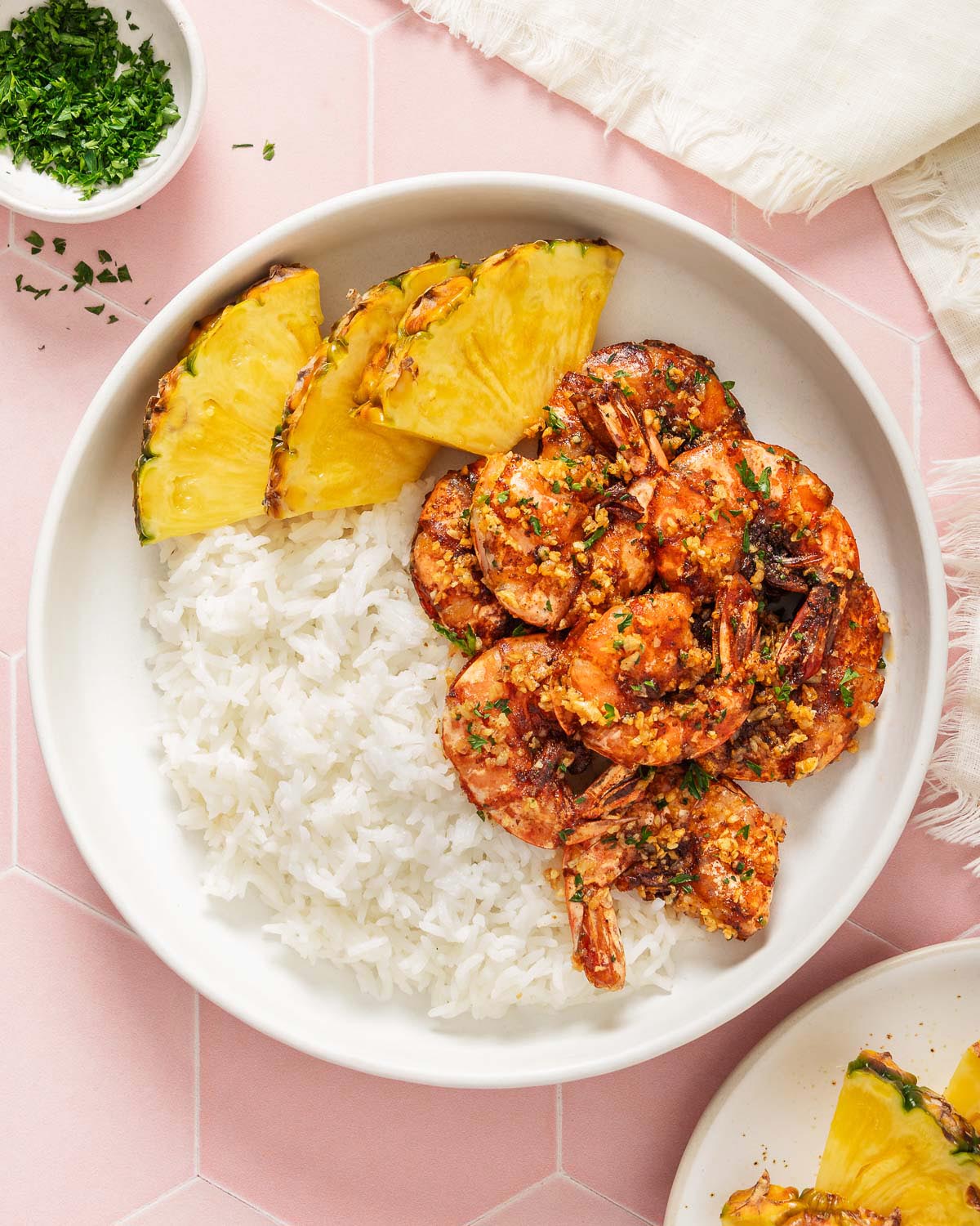 A plate with garlic shrimp, pineapple, and rice.