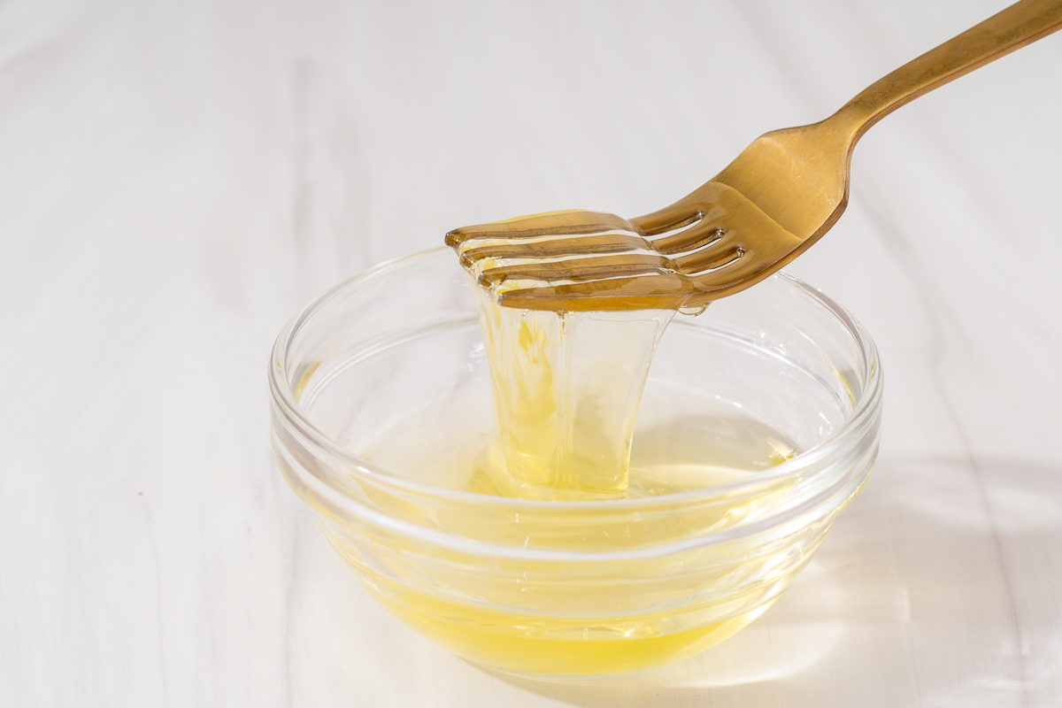 Liquifying egg whites and oil inside a small mixing bowl.