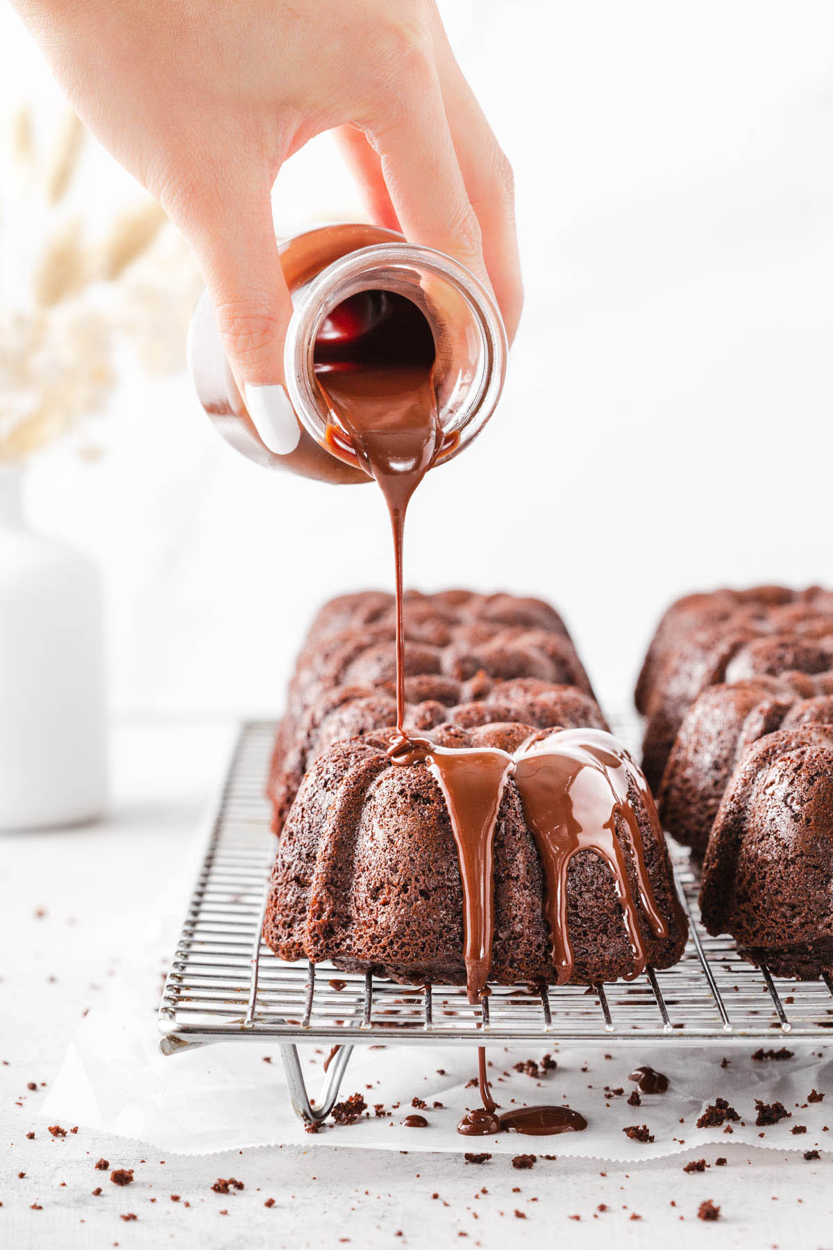 Glazing the chocolate mini bundt cakes.