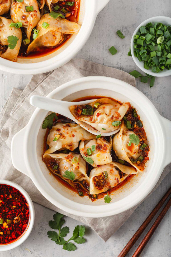 Two bowls of sichuan chili oil wontons.