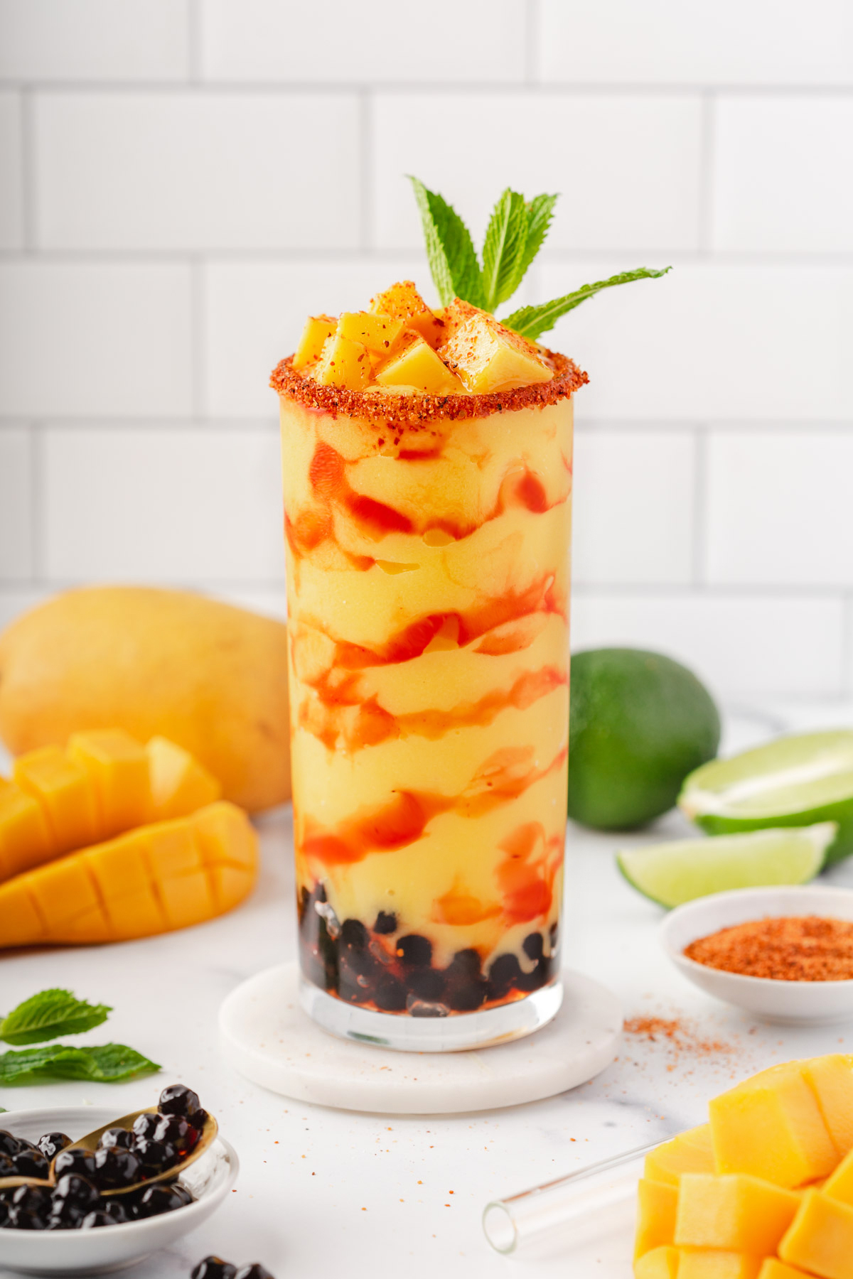 Glass of Mangonada with boba surrounded by fruit