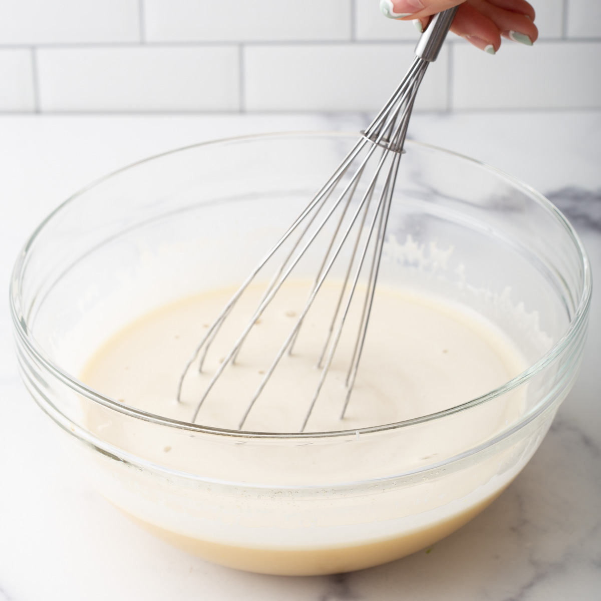 someone mixing coconut milk batter with a whisk