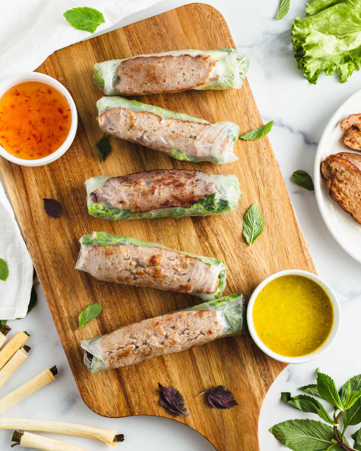 a platter of vietnamese spring rolls and sauces