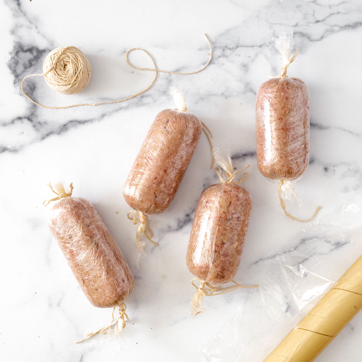 ground pork rolled and sealed in plastic wrap