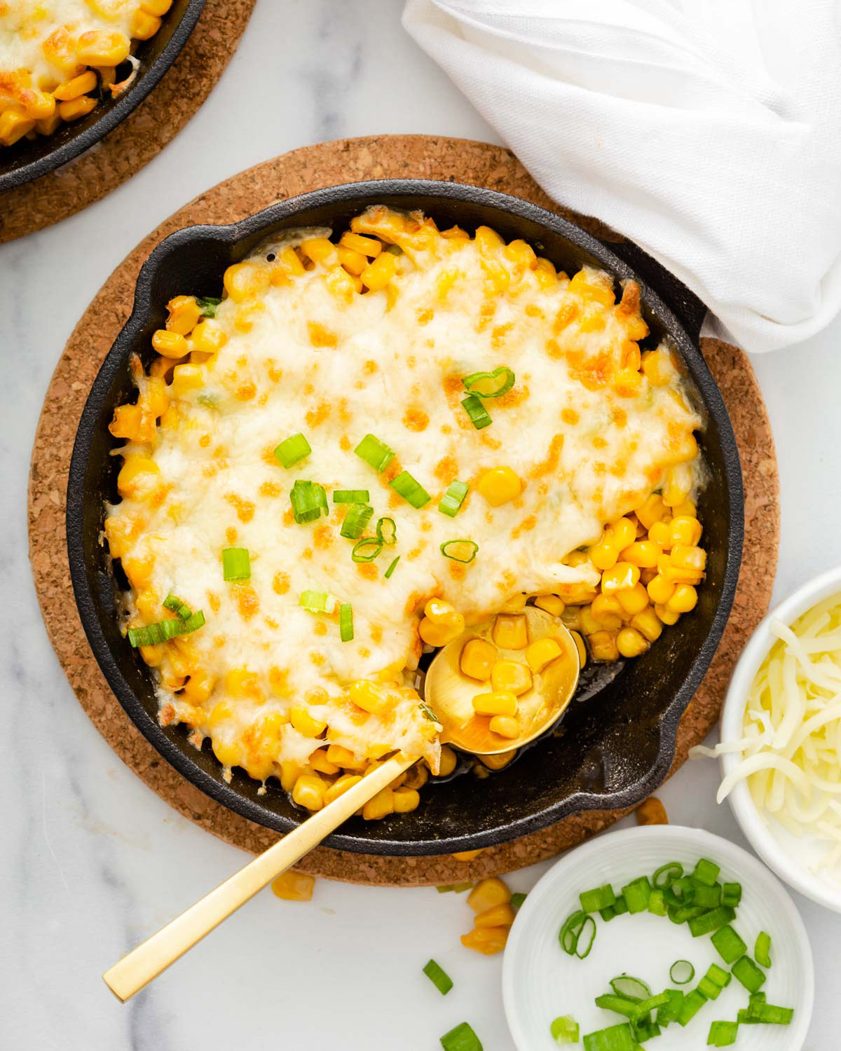Looking down into a skillet with cheesy corn