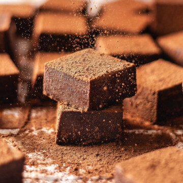 Close up of someone dusting nama chocolates with cocoa