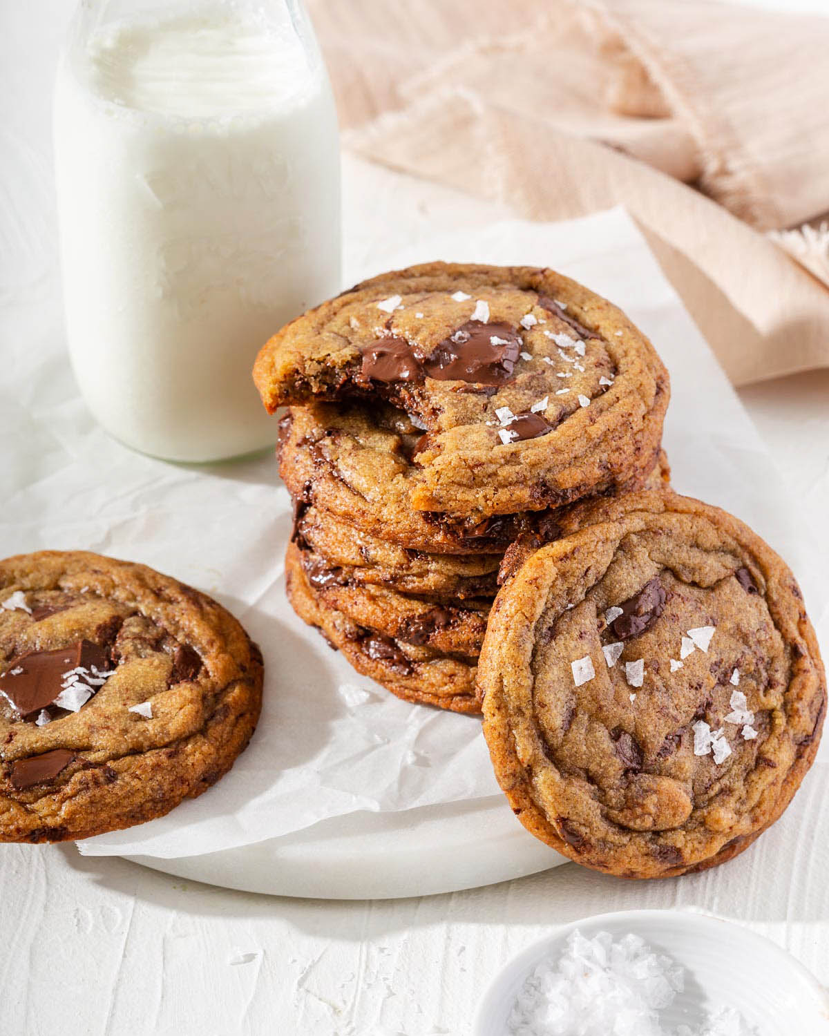 Stacks of chocolate chip cookies with a glass of milk on a tray