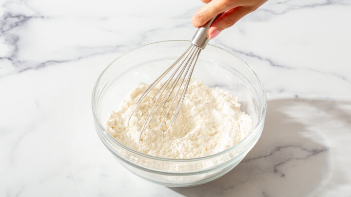 Mixing dry ingredients for cookies in a glass bowl