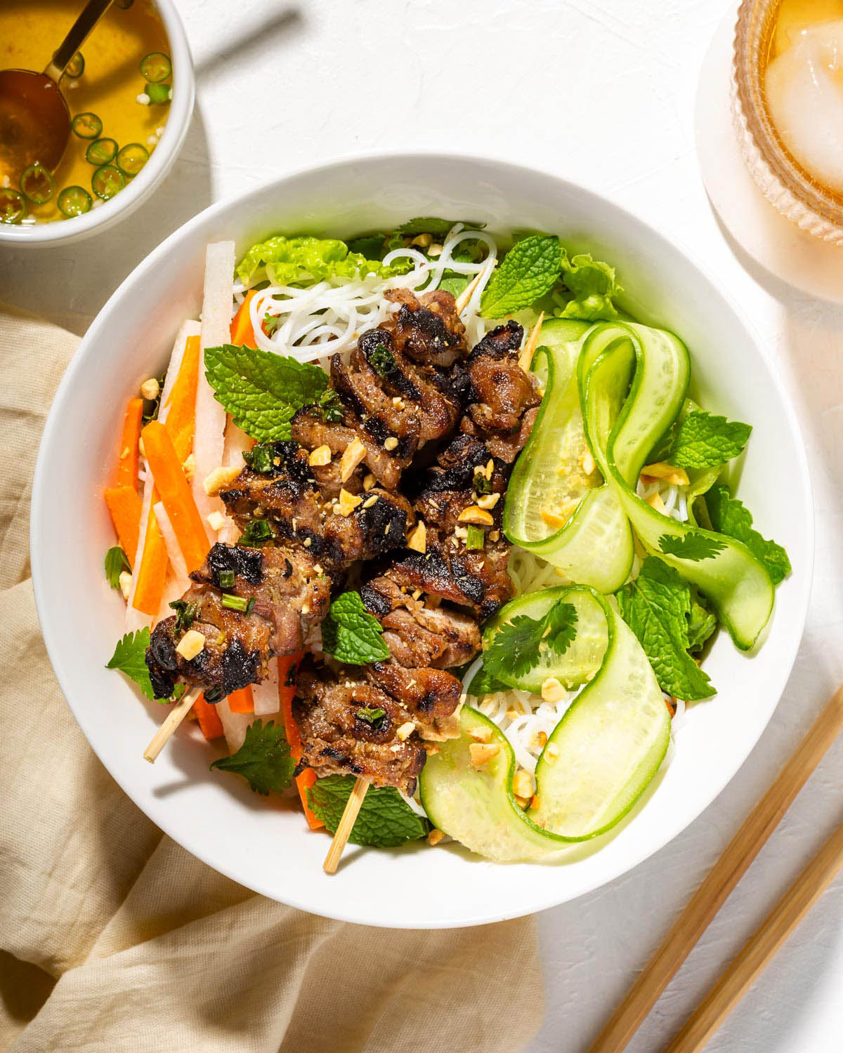 Looking down at grilled Vietnamese pork plated in a bowl.
