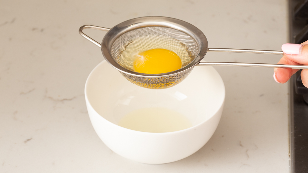 Straining the excess water from a raw egg