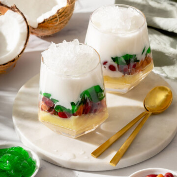 Two glasses of layered Vietnamese dessert insides glasses on a serving tray