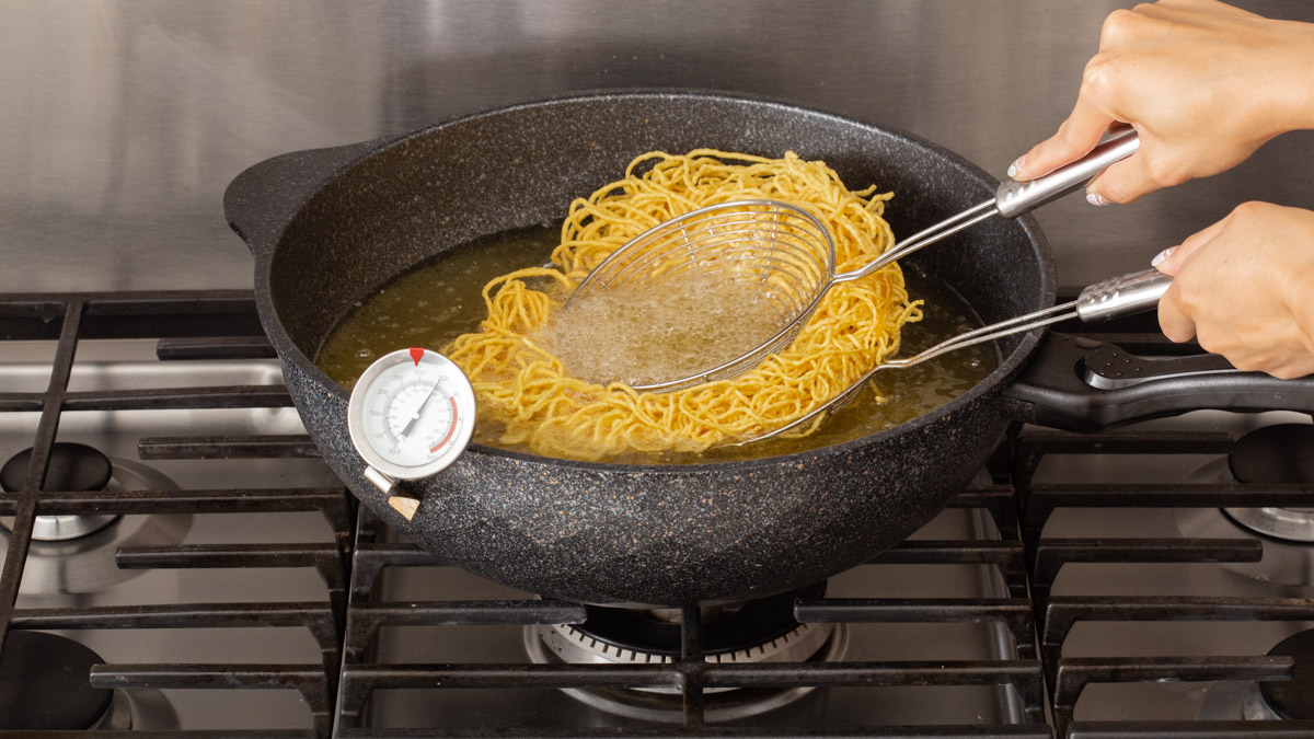 Holding a pile of noodles between two mesh strainers