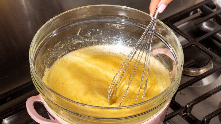 Whisking an egg mixture on a double boiler on the stove