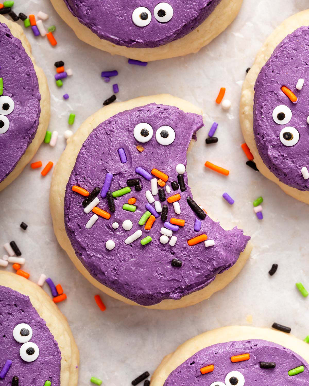 Looking down onto a cookie with a bite out it surrounded by more cookies