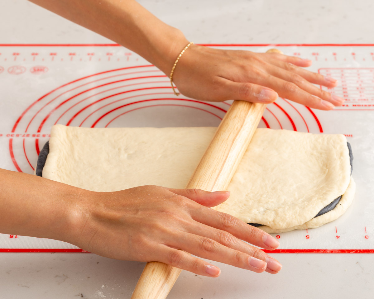 Rolling together the sandwiched doughs.