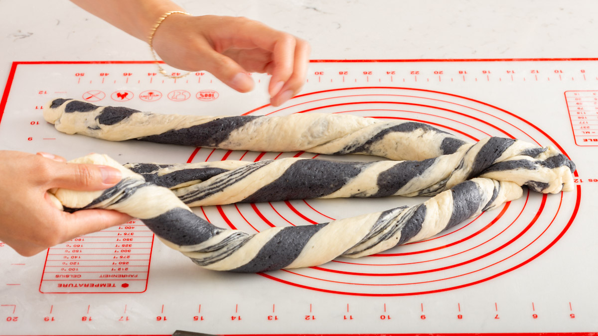 Braiding together the twisted strips of layered bread dough.