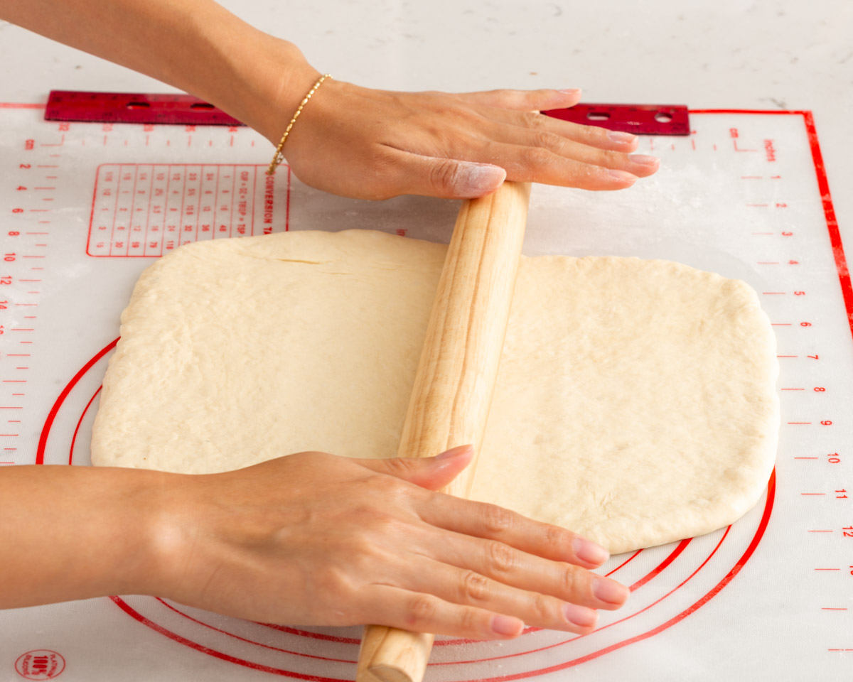 Rolling out dough with a french rolling pin on a slip mat.