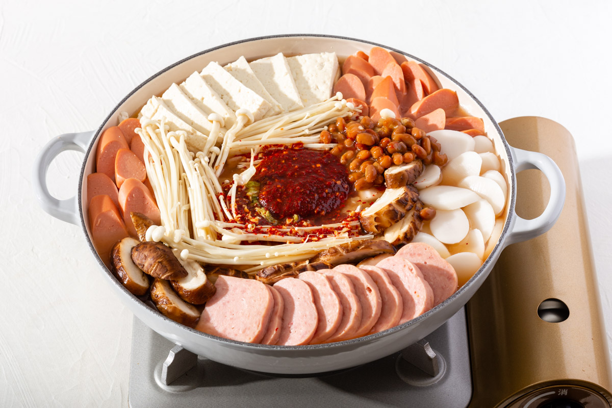 Layering in the ingredients into the pot before simmering it down.