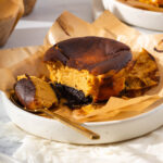 Up close of a pumpkin cheesecake on a plate with a spoon