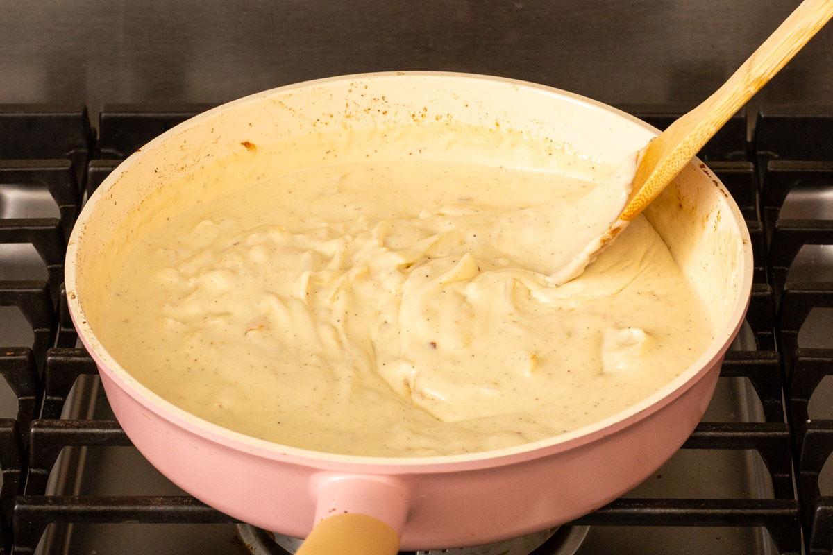 Stirring the gravy sauce on the stove for potato au gratin