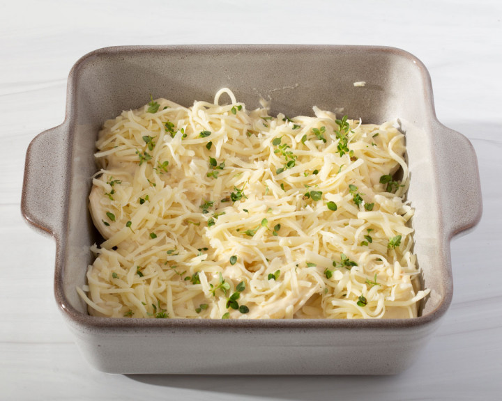 Adding a layer of cheese and thyme on top of the potatoes