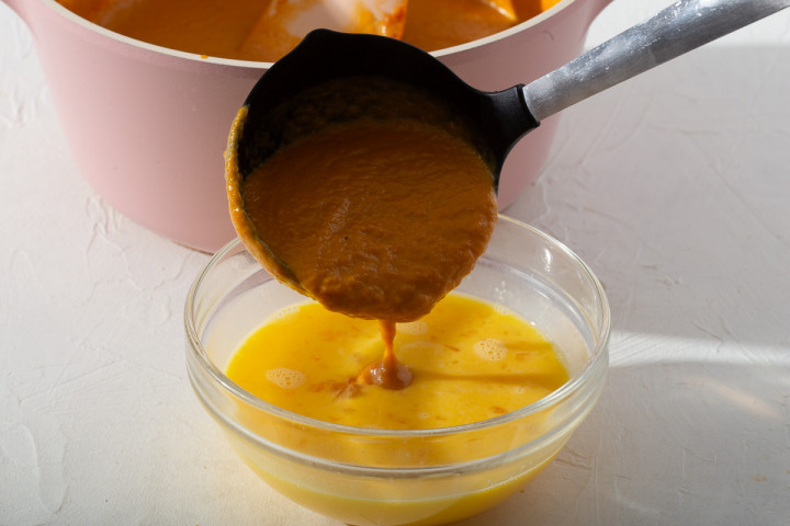 Slowly mixing the pumpkin puree and egg