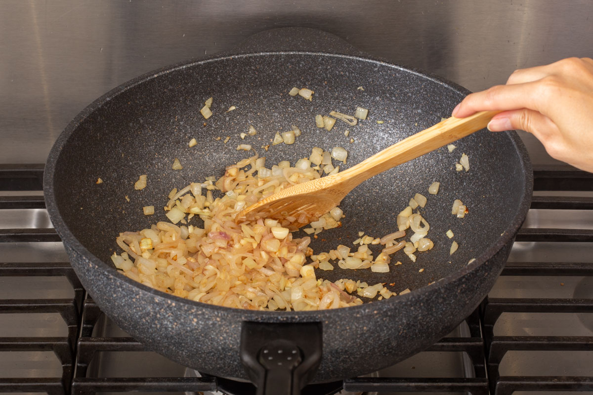 Sautéing shallots, onions, and garlic in a wok