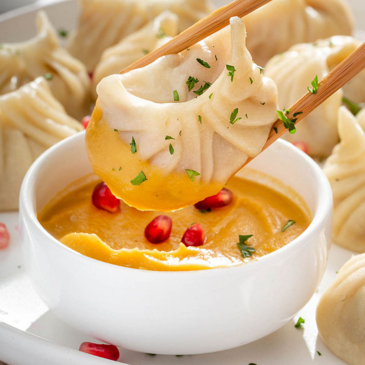 up close of a dumpling being dipped in a puree