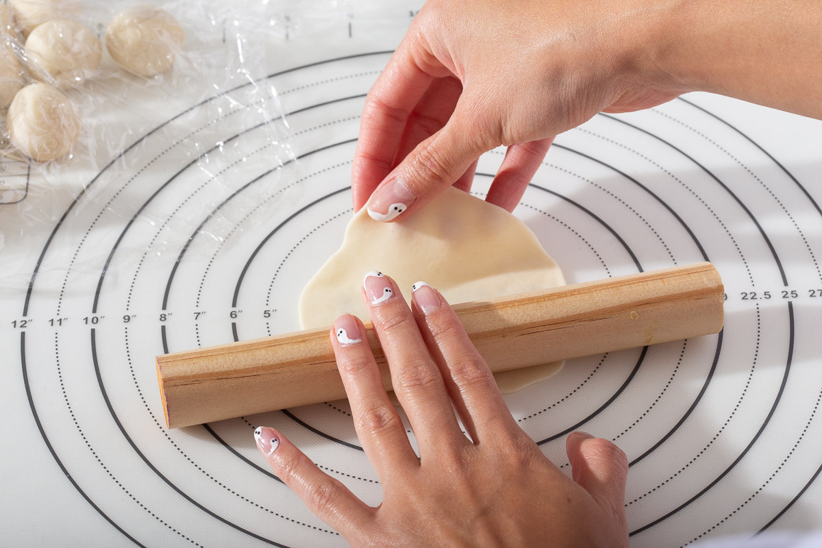 Rolling out dumpling wrappers with fresh dough