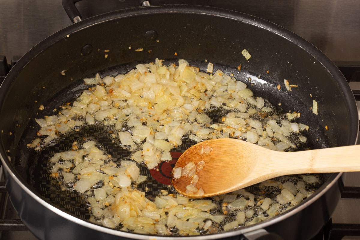 Sautéing onions and garlic in a deep skillet.