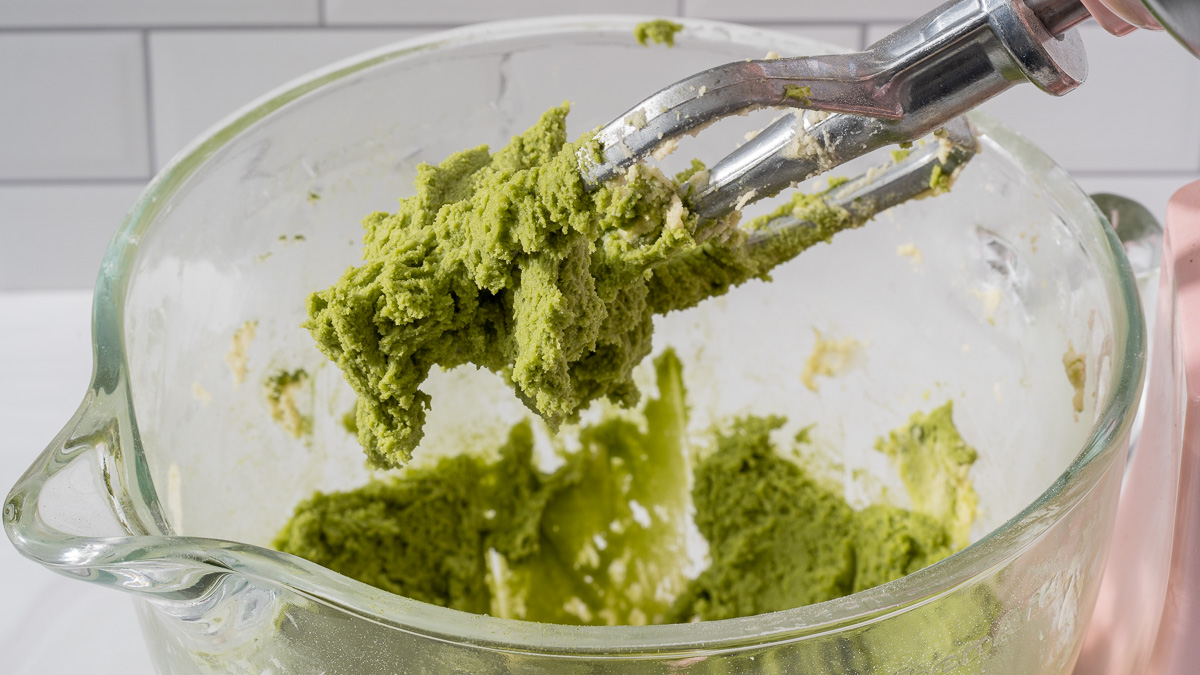 The matcha flavored portion of cookie dough blended in a stand mixer