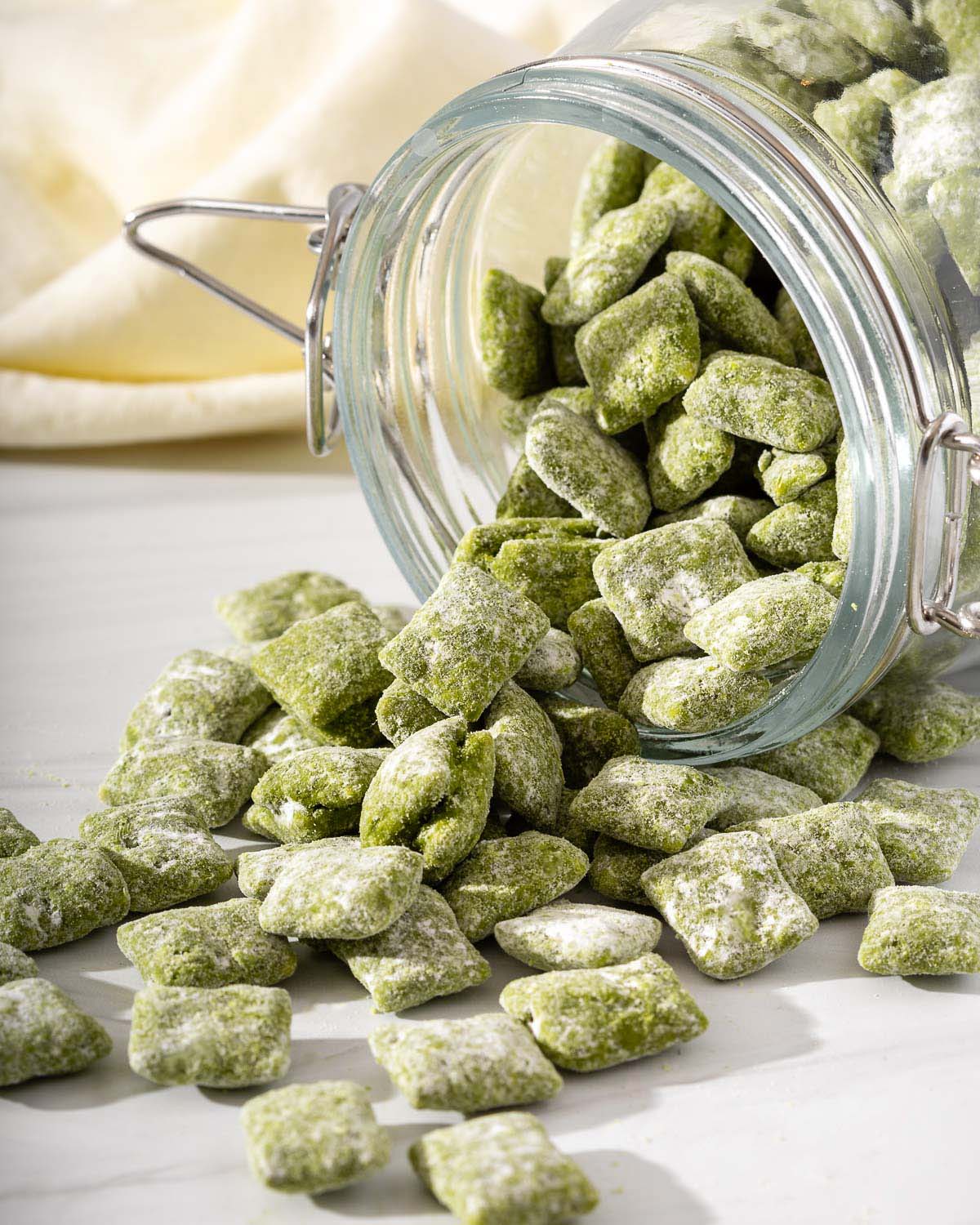 A jar spilling out green matcha puppy chow