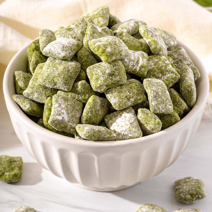 Up close of a bowl overflowing with matcha puppy chow.