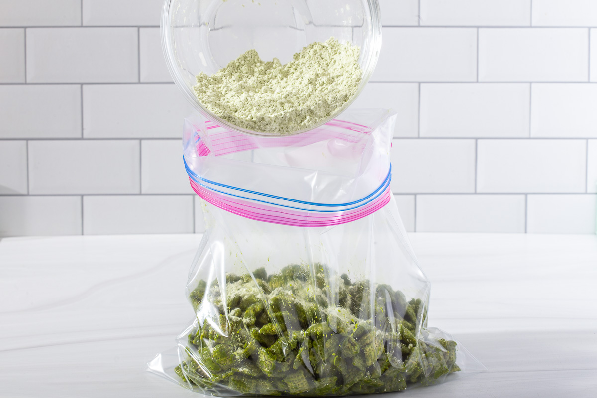 Using the ziploc bag shaking method to toss the matcha coated chex with powdered sugar.