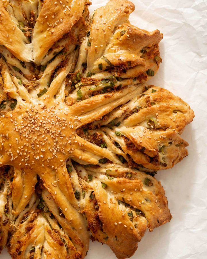 Over view of star bread with pork floss and scallions on parchment paper.