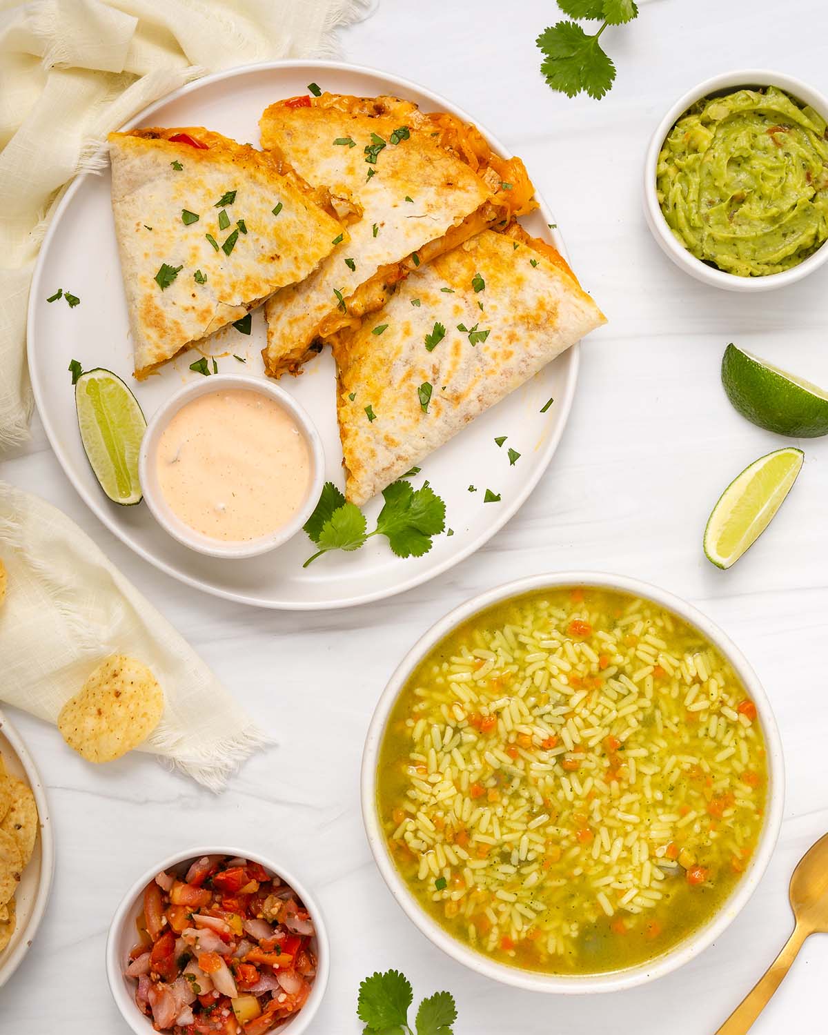 Looking down at a meal spread with quesadillas and soup