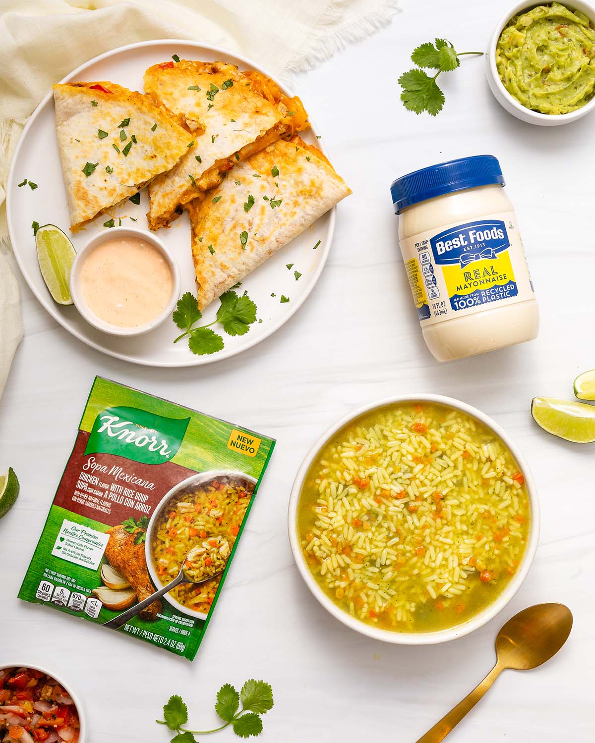 Looking down at a meal spread with quesadillas and soup with the soup package and mayo nearby