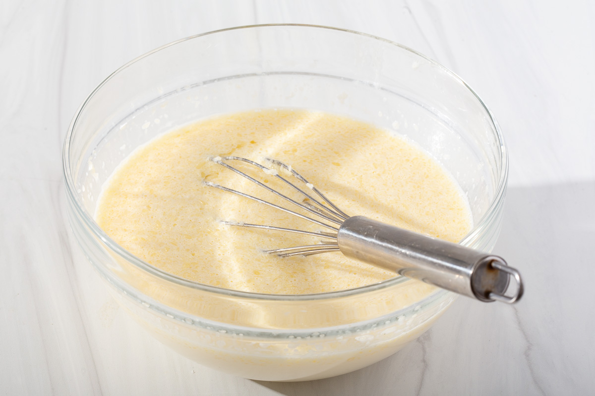 The liquid ingredients for waffles mixed together in a bowl.