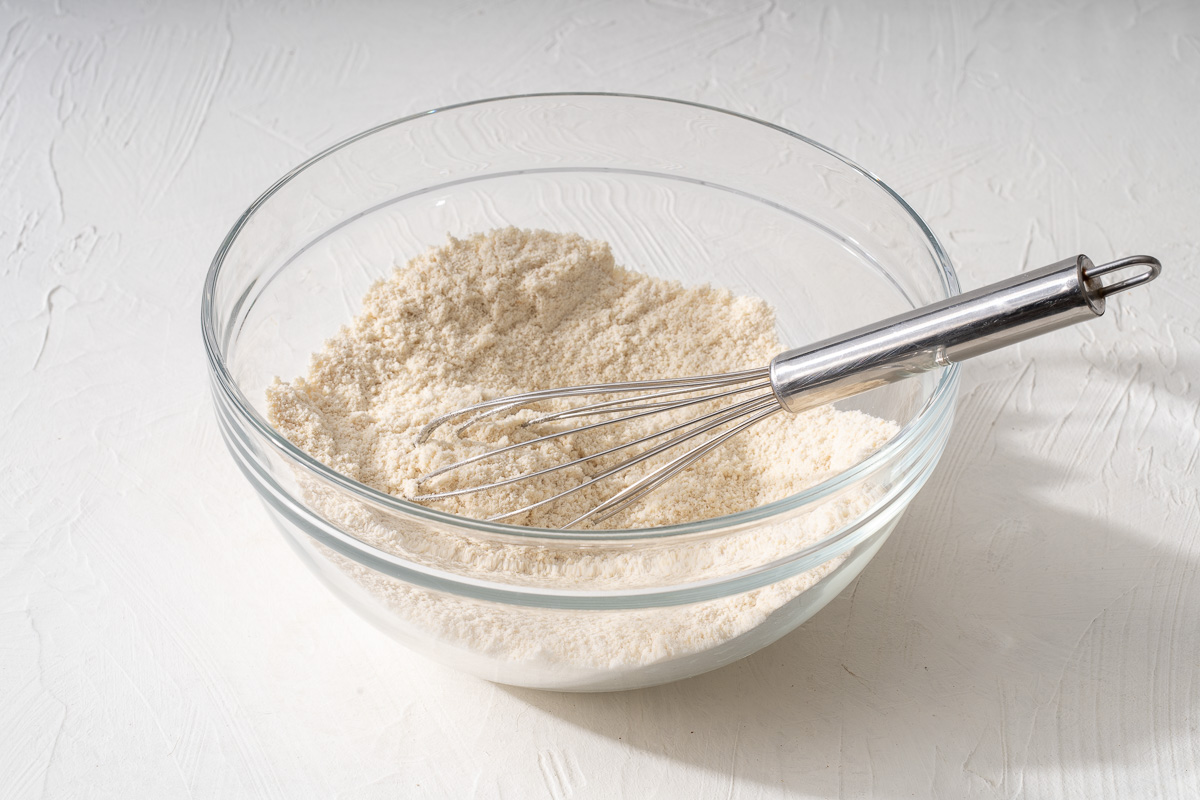 Whisking together the almond cookie dry ingredients in a glass bowl.