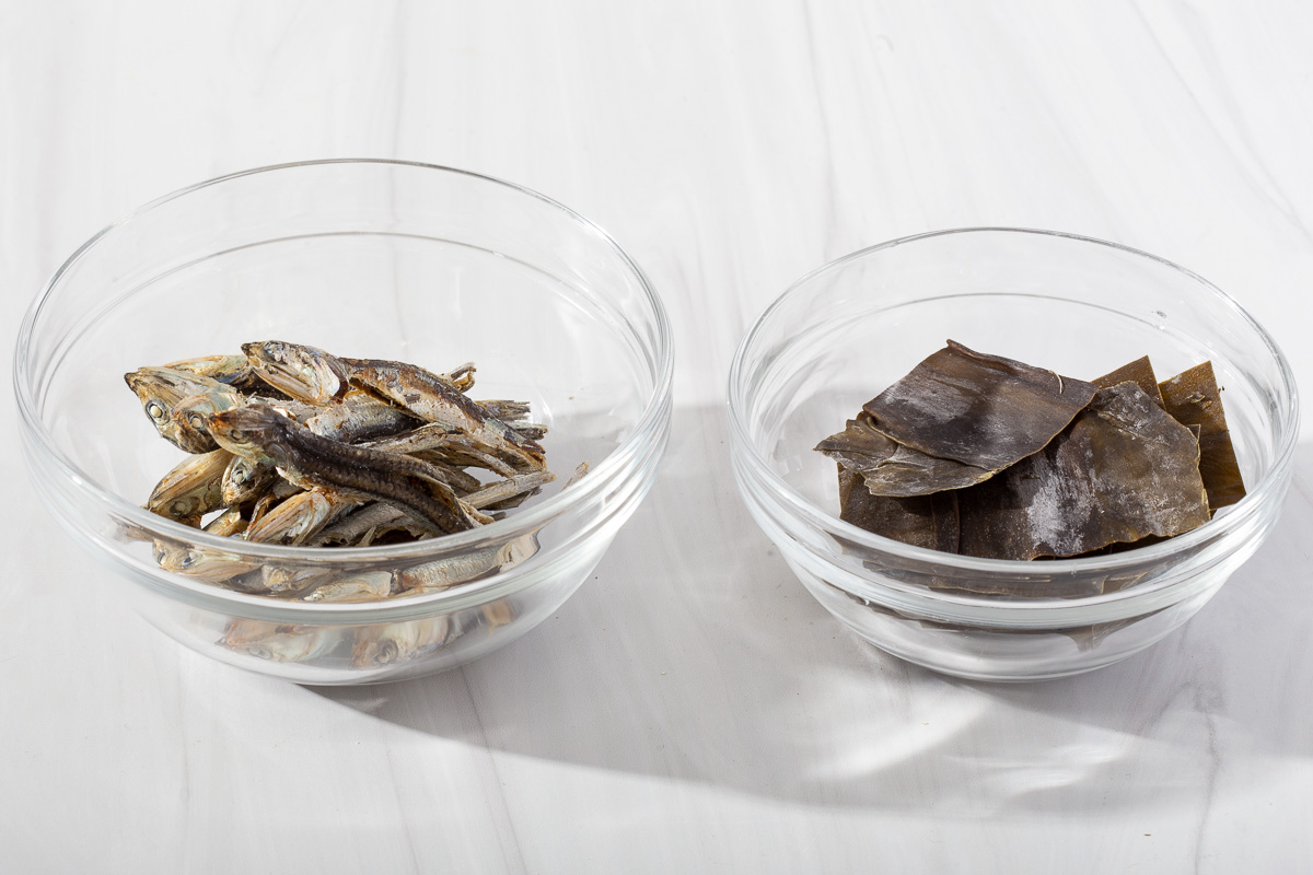 A bowl of dried frozen anchovies and a bowl of sliced kelp to reduce into an anchovy stock.