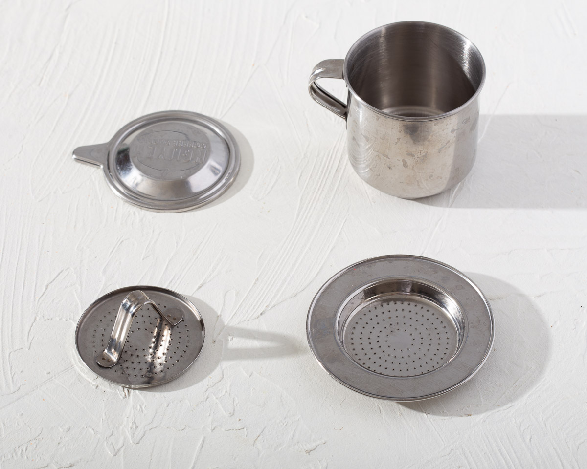 The various parts of a phin coffee filter for making Vietnamese coffee.