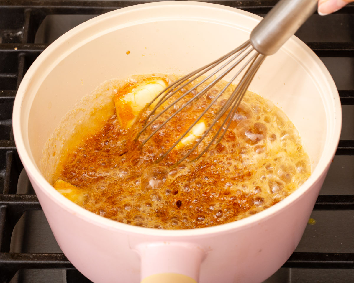 Whisking together the melted sugar and butter to form caramel.