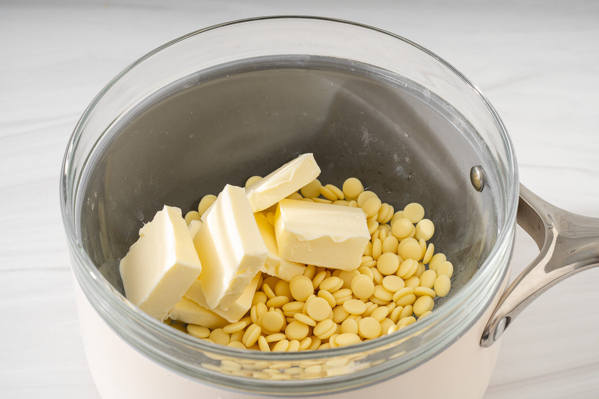 White chocolate melts and butter in a double boiler setup for melting.