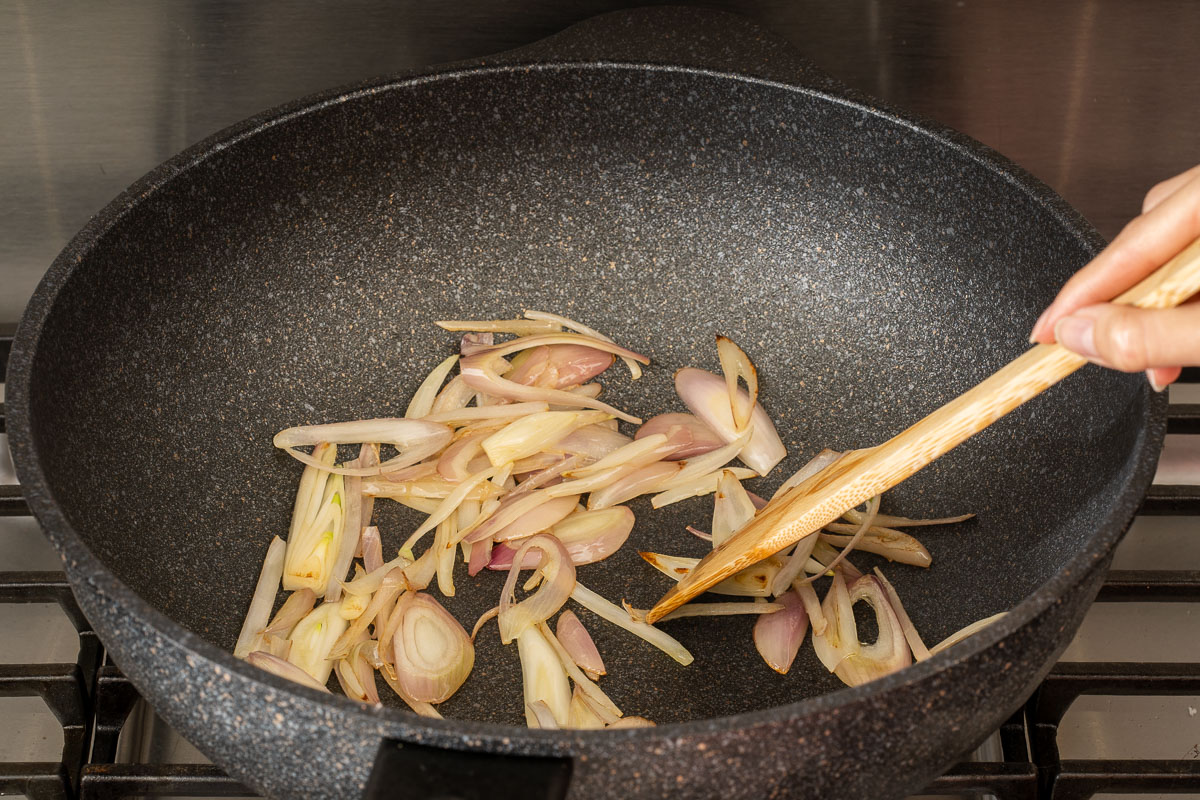 Caramelizing shallots in a wok.