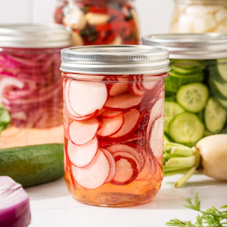 Jars of vegetables quick pickling on a counter.