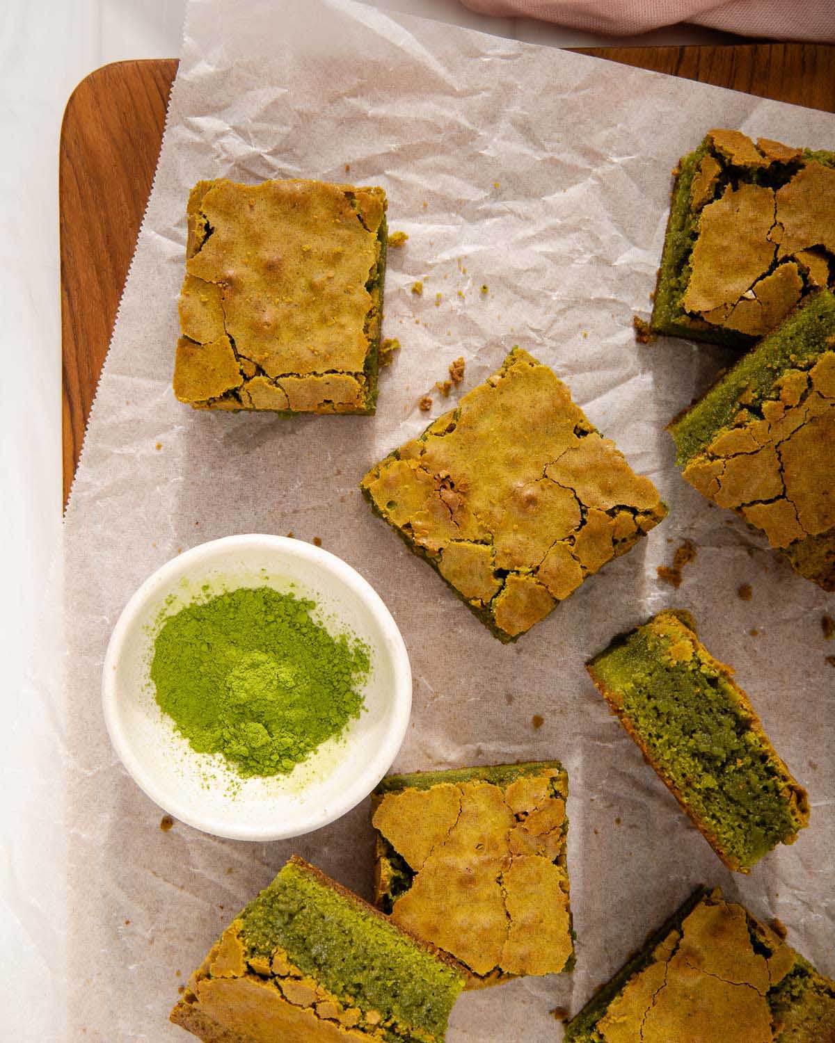 A tray of brownies with matcha powder nearby.
