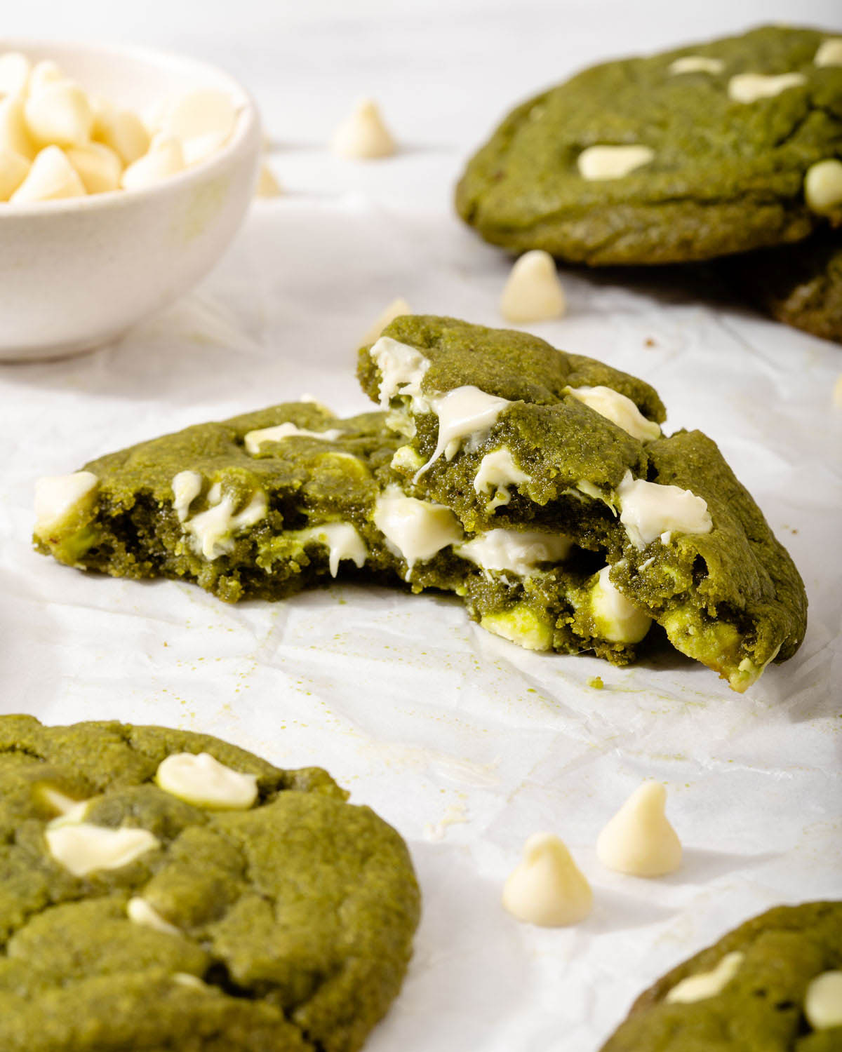 Up close of a freshly baked matcha cookie with melted white chocolate chips inside.