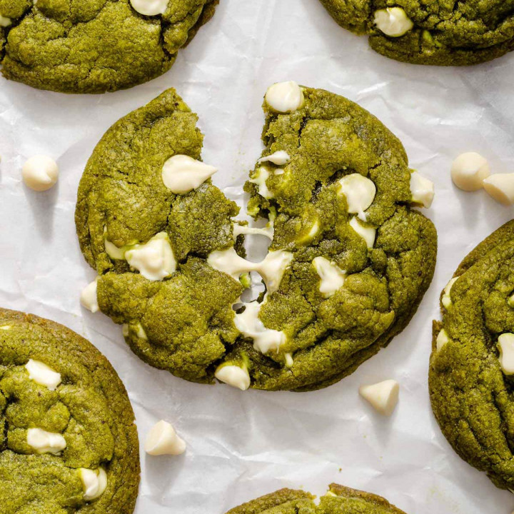 Up close of a torn open melty white chocolate matcha cookie.